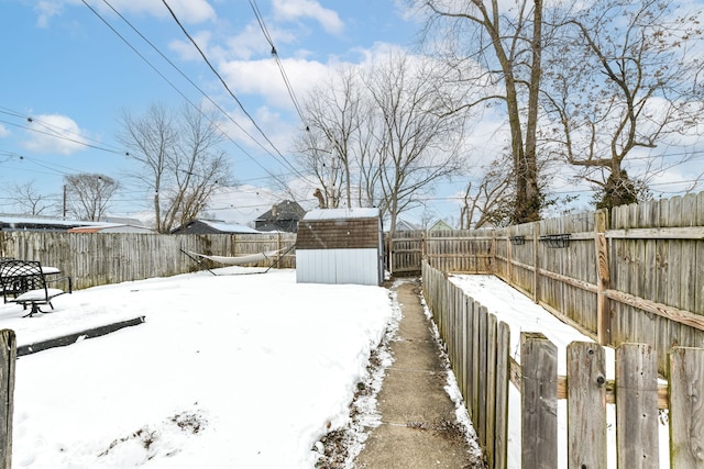 yard layered in snow featuring a shed