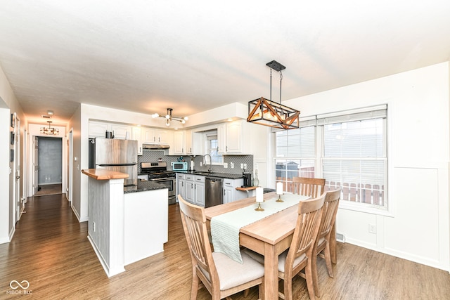 dining area featuring a wealth of natural light, hardwood / wood-style floors, and sink