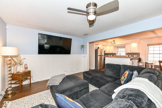 living room with ceiling fan, sink, and dark hardwood / wood-style floors