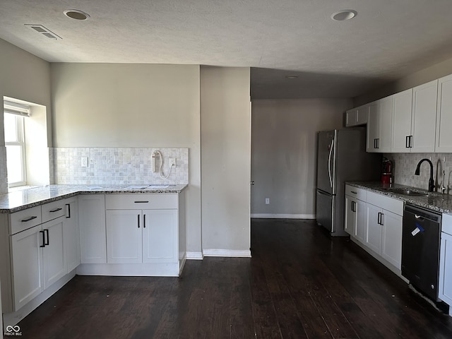 kitchen featuring white cabinetry, sink, light stone countertops, black dishwasher, and decorative backsplash