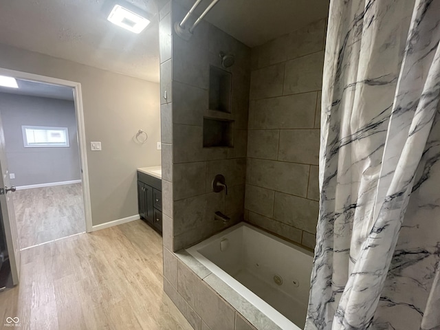 bathroom with hardwood / wood-style floors, vanity, and shower / tub combo with curtain