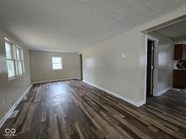 unfurnished room featuring a textured ceiling and dark wood-type flooring