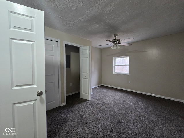 unfurnished bedroom featuring dark colored carpet, ceiling fan, and a textured ceiling