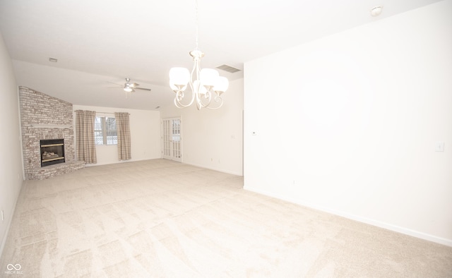 unfurnished living room featuring ceiling fan with notable chandelier, a fireplace, vaulted ceiling, and light carpet