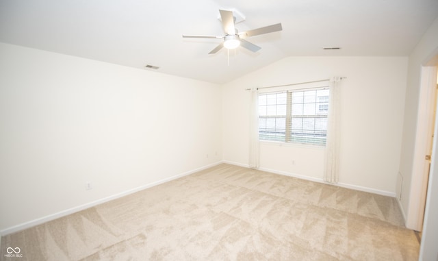 empty room featuring ceiling fan, light colored carpet, and lofted ceiling