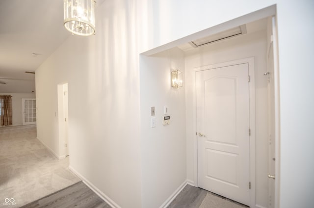 hall with a notable chandelier and wood-type flooring