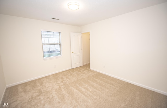 unfurnished room featuring light carpet