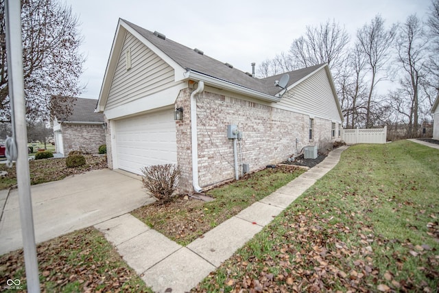 view of side of home with central AC unit, a garage, and a lawn