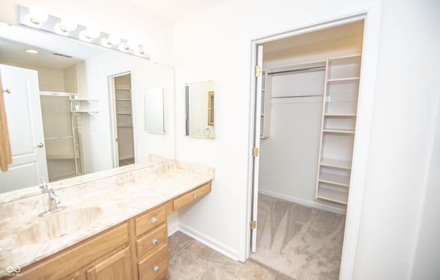 bathroom with a shower with door and vanity