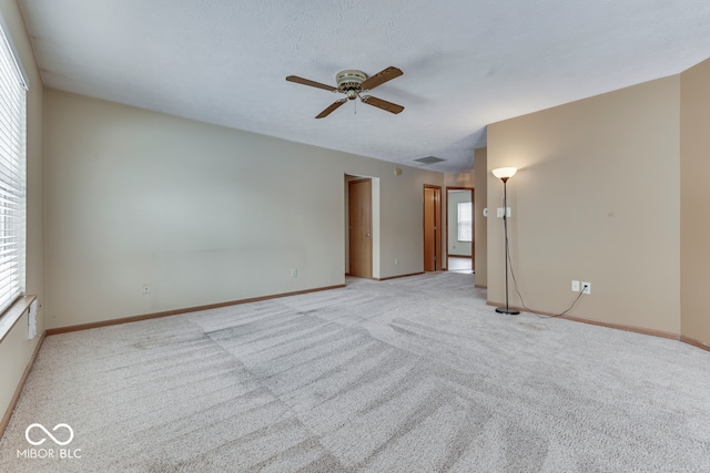 carpeted spare room with a textured ceiling and ceiling fan