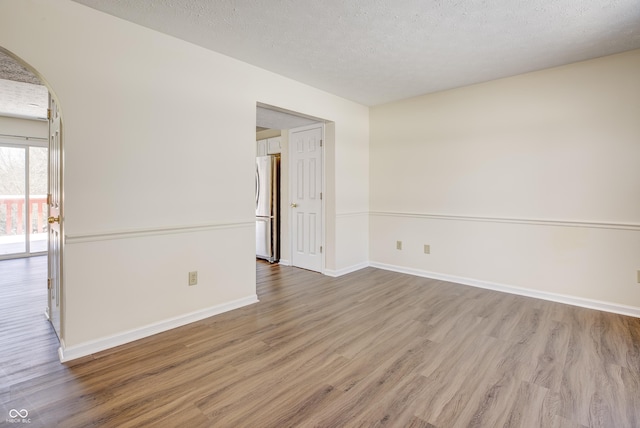 empty room featuring a textured ceiling and hardwood / wood-style flooring