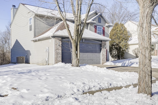 front of property with central AC unit and a garage