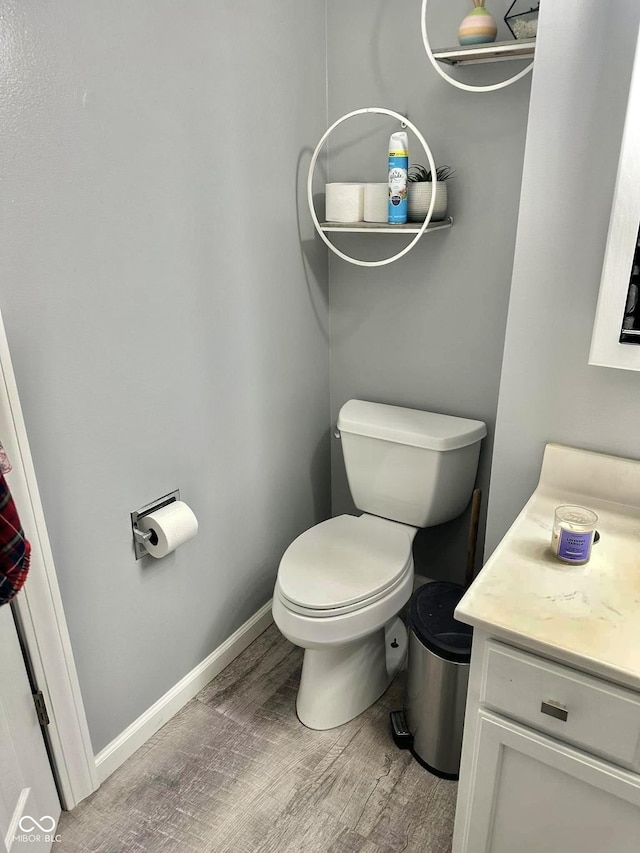 bathroom featuring toilet, wood-type flooring, and vanity