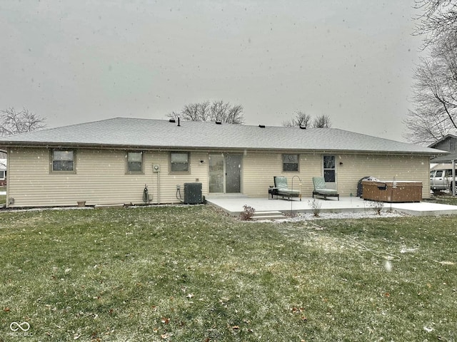 back of property featuring a patio area, cooling unit, a hot tub, and a lawn