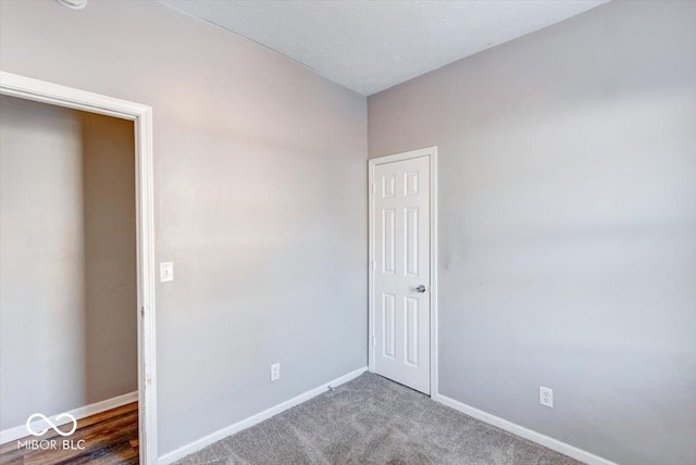 unfurnished room with dark colored carpet