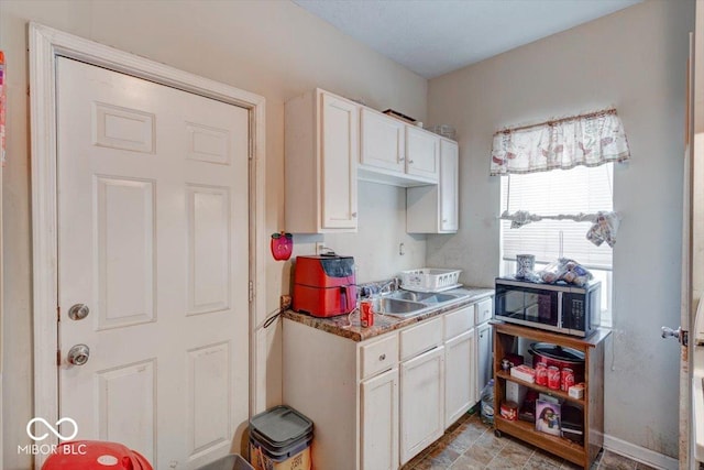 kitchen featuring sink and white cabinets