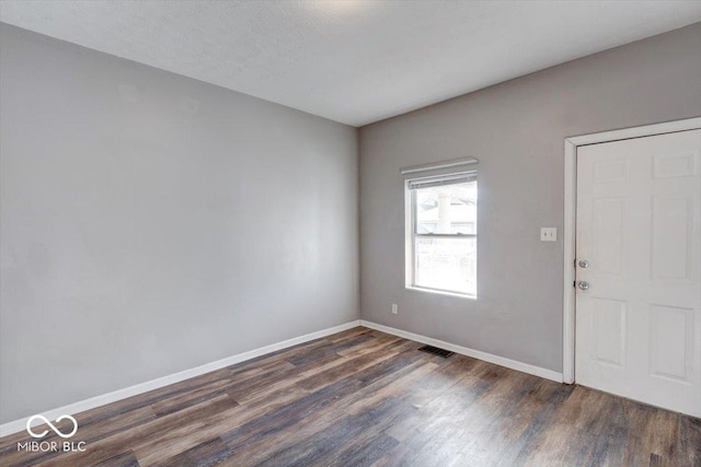 interior space with dark wood-type flooring and a textured ceiling