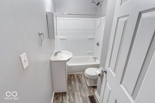 full bathroom with vanity, hardwood / wood-style flooring, shower / tub combination, and toilet