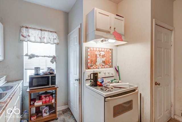 kitchen with white electric stove, white cabinetry, and sink