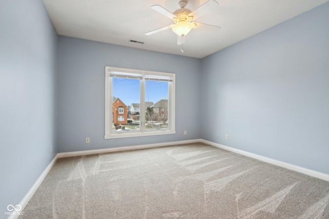 spare room featuring ceiling fan and carpet