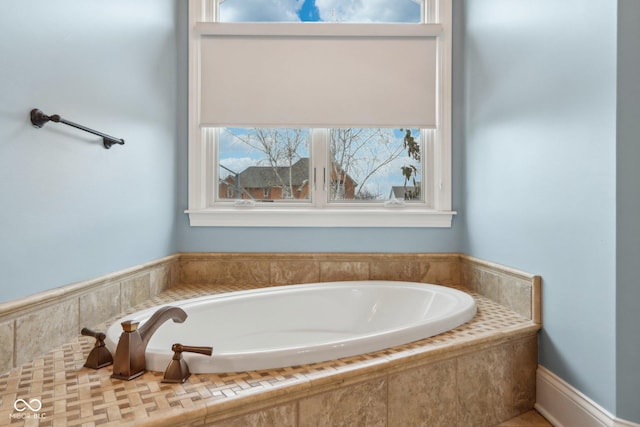 bathroom featuring tiled tub and a healthy amount of sunlight