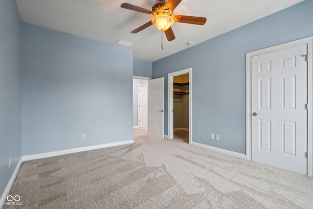 unfurnished bedroom featuring ceiling fan, a walk in closet, carpet floors, and a closet