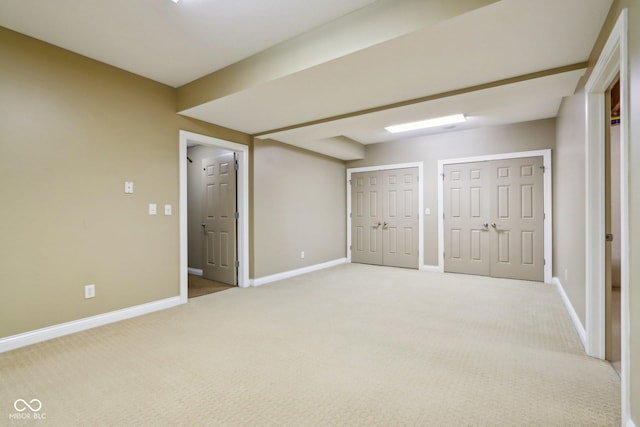 unfurnished bedroom with multiple closets and carpet