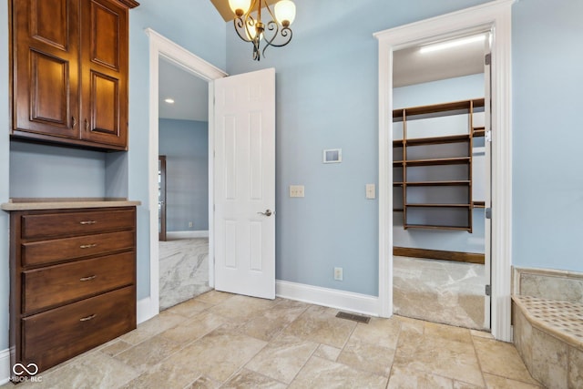 interior space with light carpet, a notable chandelier, and a closet