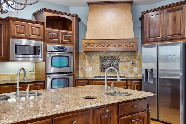 kitchen with appliances with stainless steel finishes, sink, decorative backsplash, custom exhaust hood, and light stone counters