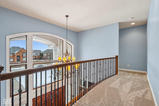 hall featuring carpet floors and a notable chandelier