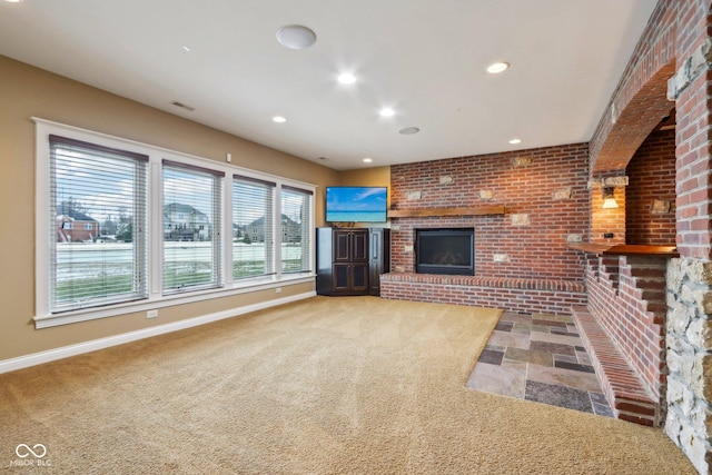 unfurnished living room featuring brick wall, a fireplace, and carpet floors