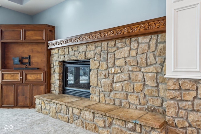 interior details featuring a fireplace and carpet