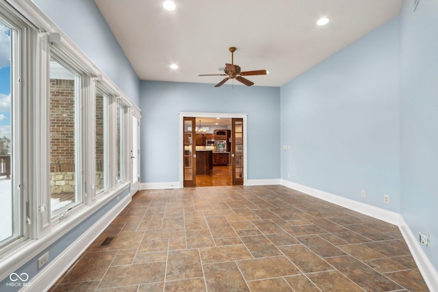 spare room featuring ceiling fan and plenty of natural light