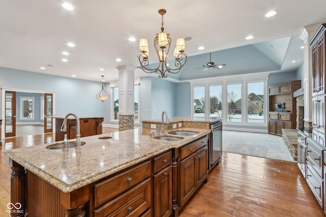 kitchen featuring hanging light fixtures, sink, decorative columns, and a spacious island