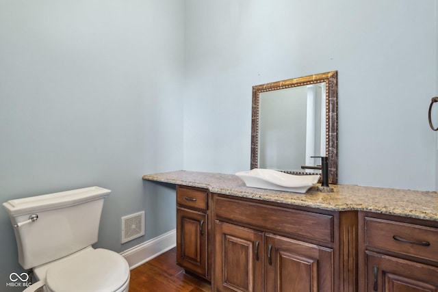 bathroom with vanity, wood-type flooring, and toilet