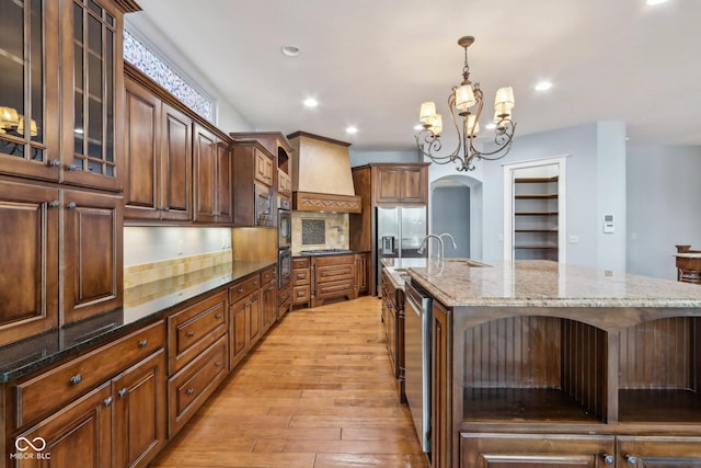 kitchen featuring a large island, hanging light fixtures, dark stone countertops, beverage cooler, and decorative backsplash