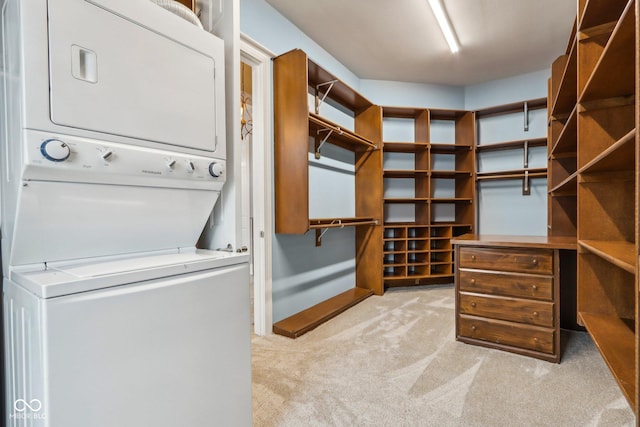 walk in closet featuring stacked washing maching and dryer and light carpet