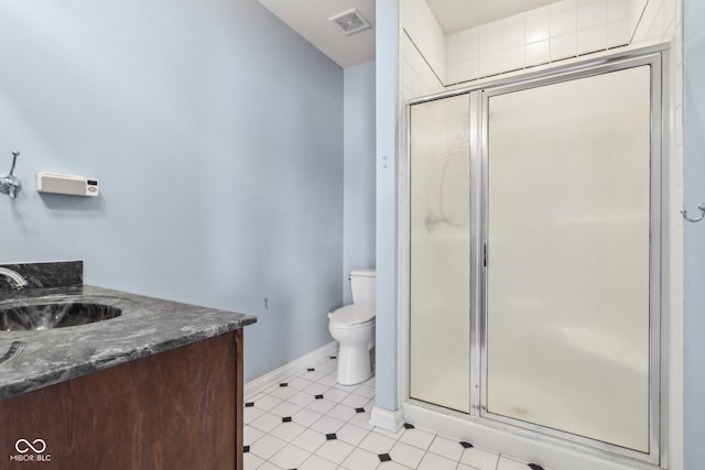 bathroom featuring vanity, a shower with door, and toilet