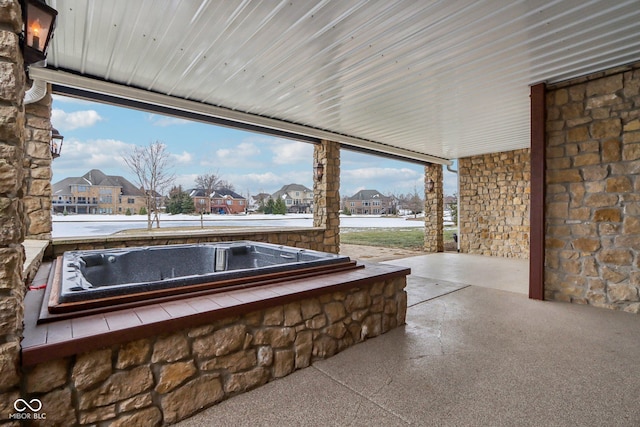 view of patio / terrace with a hot tub and a water view