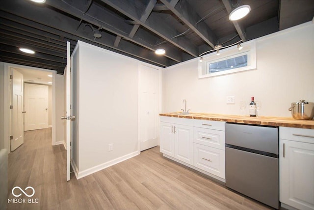 kitchen featuring white cabinetry, fridge, light wood-type flooring, and butcher block counters