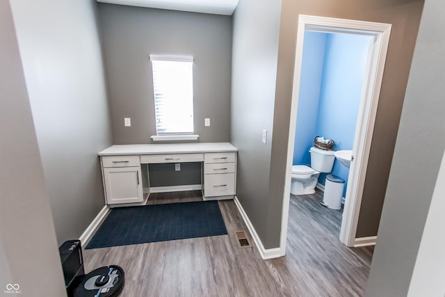 bathroom featuring wood-type flooring, vanity, and toilet