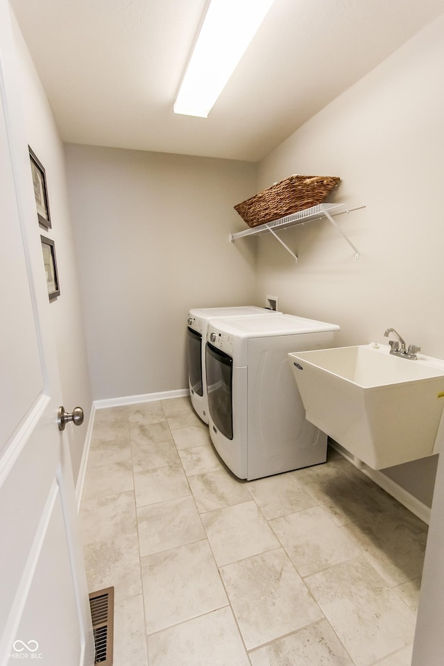 clothes washing area with sink and independent washer and dryer