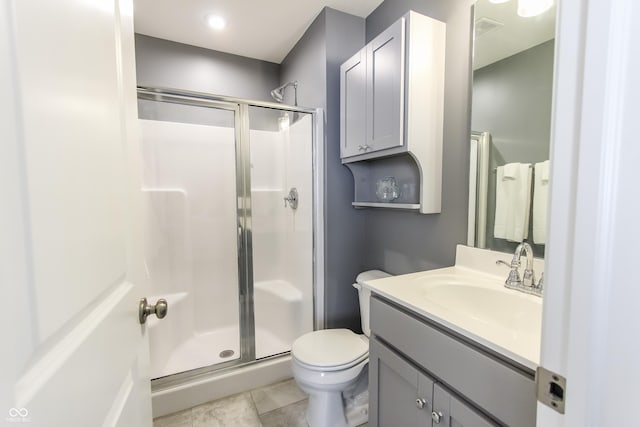 bathroom featuring tile patterned flooring, vanity, toilet, and walk in shower