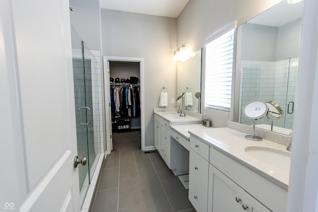 bathroom featuring tile patterned floors, a shower with door, and vanity