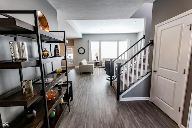 foyer entrance with dark hardwood / wood-style flooring and a textured ceiling