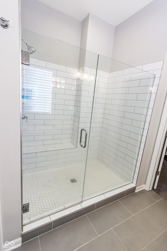 bathroom featuring a shower with shower door and tile patterned flooring