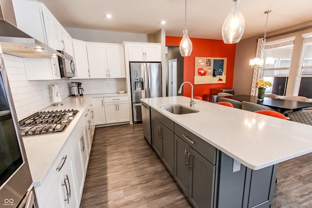 kitchen featuring white cabinetry, hanging light fixtures, and stainless steel appliances