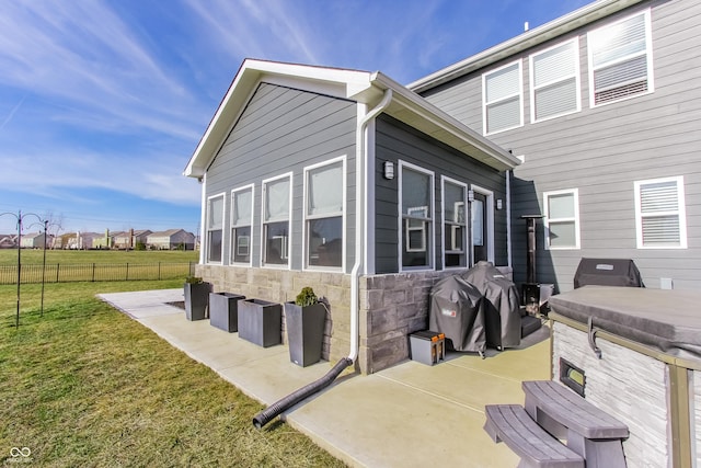 view of side of property with a patio area and a lawn