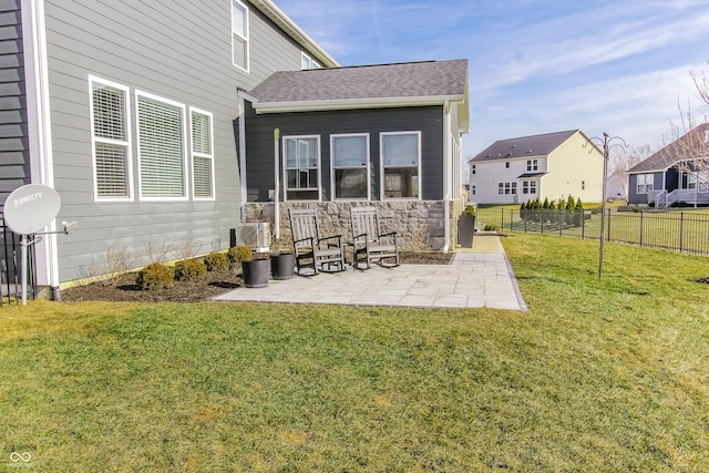 rear view of property featuring a lawn and a patio