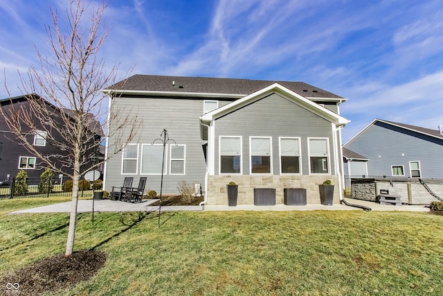 back of house with a lawn and a patio area